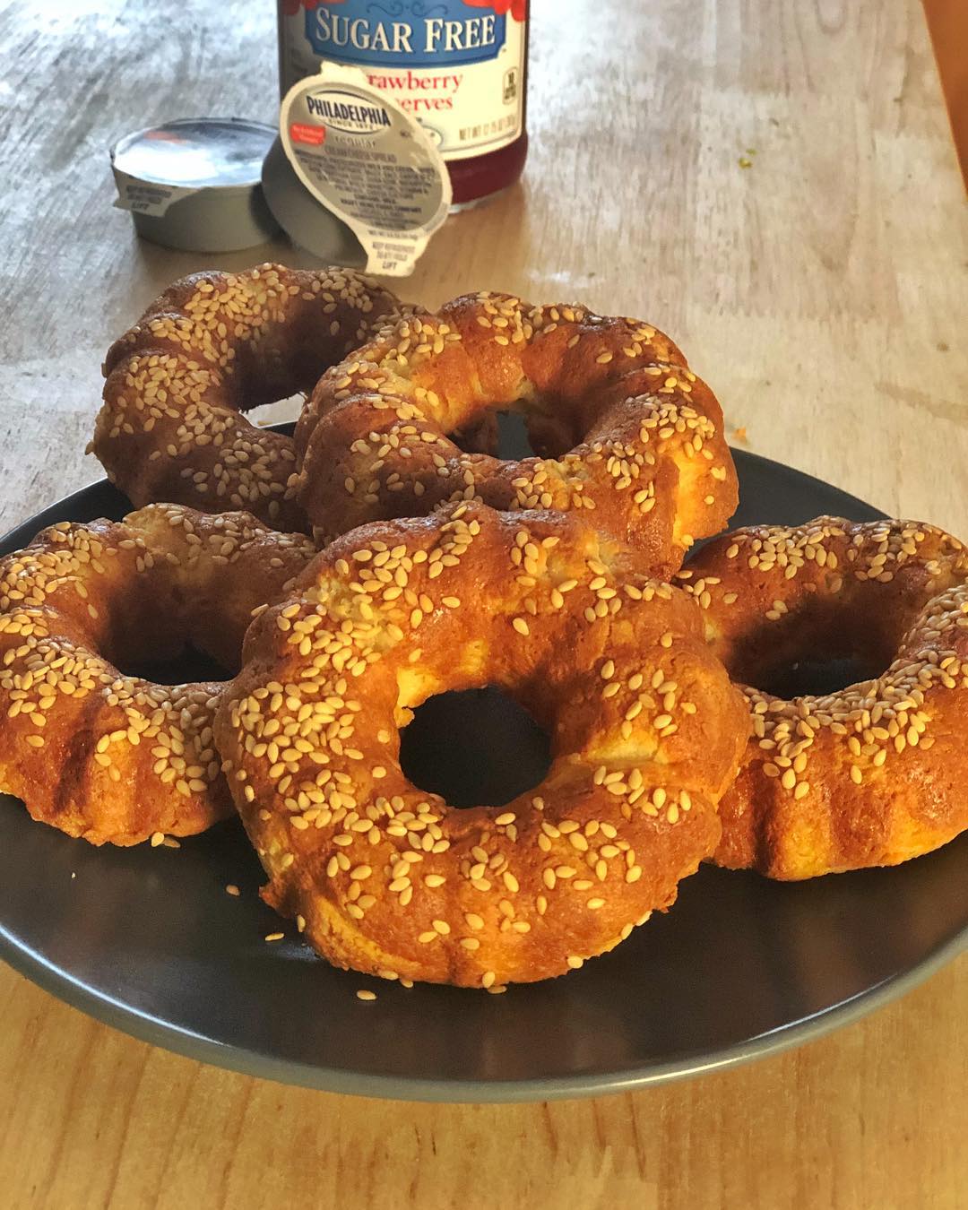 I made bagels today!! I tried to get a doughnut pan and ended up with a mini bundt cake pan instead.. oh well, they looked and tasted wonderful!! I grew up eating bagels with strawberry jam and cream cheese so I’m absolutely thrilled to be able to again, and keep it under 4g (including the strawberry jam!)
——
1 cup almond flour
1 egg
1 tsp Xanthan Gum
1.5 cups Mozzarella Cheese
2 Tbsp Cream Cheese
——
Preheat over to 400. Beat the egg and then fold in Almond Flour and Xanthan Gum till fully mixed.. Make sure to finish this step prior to mixing the mozzarella and cream cheese in a microwave safe bowl and then heating 1 minute at a time until melted.. combine the two bowls and mix completely; I finished by mixing with my hands.. I sprayed my pan with coconut oil spray and sprinkled sesame seeds into each spot.. I didn’t evenly distribute the dough so I ended up with 5 bagels instead of 6.. I sprinkled more sesame seeds on top of the dough and then put in the over for 15 minutes. Mine might have stayed and extra minute which made them all brown and toasty… but I sliced while still warm and spread on some cream cheese and then sugar free strawberry spread.. without the spread, the bagels should be about 2g carbs each.. with it, they should be about 4g net carbs… I’m a happy camper with this easy recipe